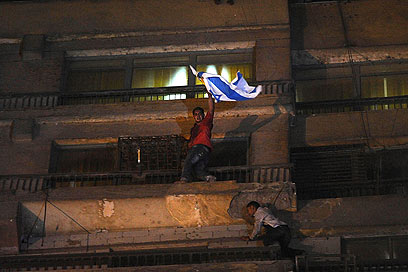 מפגין עם דגל ישראל בבניין השגרירות (צילום: AP)
