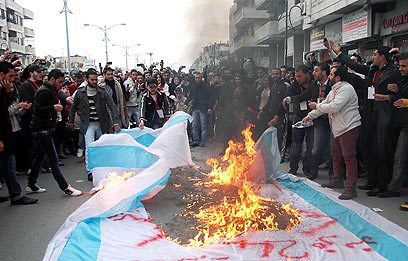 לא רק נגד אסד. בעיר חומס שרפו את דגל ישראל (צילום: AFP / SANA)