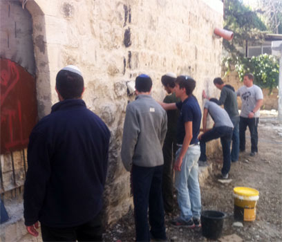 הצעירים מנקים את קירות המסגד. "מוחקים כתם" (צילום: עמיחי בן סעדון)