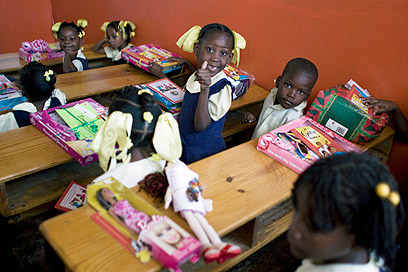 ילדים בהאיטי נרגשים לפתוח את מתנות החג שחילק ארגון צדקה (צילום: AP)