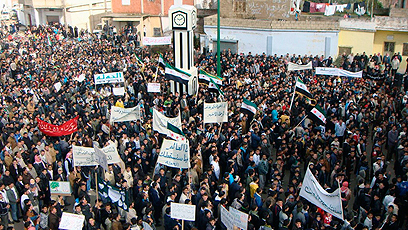 אזרחים סורים מפגינים נגד משטר אסד בעיר חולה, ליד חומס (צילום: רויטרס)