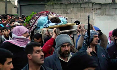 עשרות הרוגים בהפצצות הלילה. הלוויה בחומס (צילום: AP)