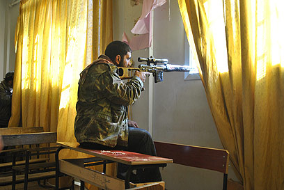 מורד סורי דרוך בעיר חומס (צילום: AP)