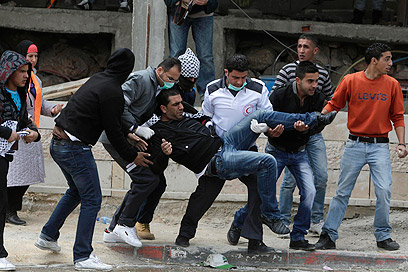 מפנים פצוע פלסטיני בקלנדיה (צילום: רויטרס)