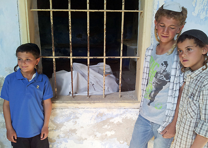הנערים ליד הבית הנטוש (צילומים: אתר חב"ד, שטורעם.נט)