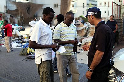 בודקים תעודות לאפריקנים בתל-אביב (צילום: EPA)