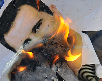 מעלים באש את תמונתו של אסד ליד חלב (צילום: AFP)