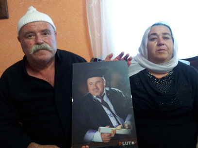 הוריו של ג'והרי עם תמונתו, היום במג'דל שמס (צילום: חסן שעלאן)