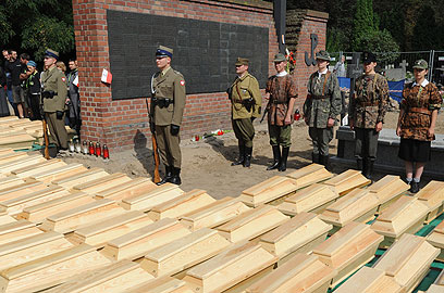 חיילי צבא פולין חולקים כבוד לגיבורים ששרידיהם בארונות (צילום: AP)