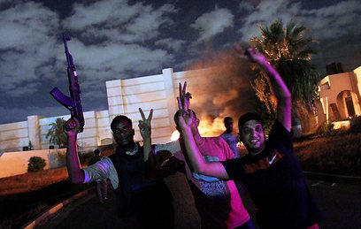 המפגינים חוגגים לאחר הפשיטה על מחנה "אנסר אל-שריעה" (צילום: AFP)