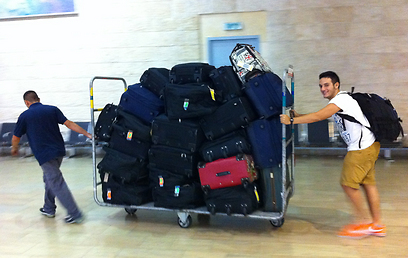 הבן אייזיק והמזוודות בנתב"ג. חלק מהציוד נותר במילאנו  (צילום: תרי לוי)