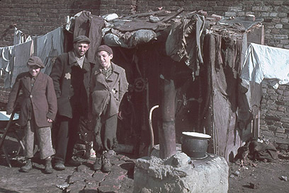גבר וילדים ליד מחסה מאולתר בגטו קוטנו, 1940 (צילום: Gettyimages)