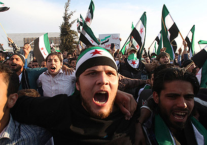 מפגינים עם דגלי סוריה המהפכנית ביום הקורבן (צילום: רויטרס)