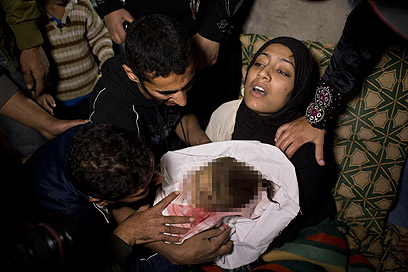 תינוקת שנהרגה בתקיפה בעזה. לטענת הפלסטינים, 16 אזרחים נהרגו עד כה ברצועה (צילום: AP)