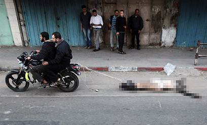 גופת אחד מ"משתפי הפעולה" נגררת ברחוב (צילום: רויטרס)