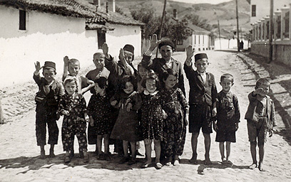 בתמונה זו נראים חיילים גרמנים כופים על ילדים יהודים להצדיע להם במועל יד. הילדים מחייכים, אולי בלית ברירה, ונראה שאינם מבינים שהפכו לכלי משחק בידיהם של חיילים שאיבדו צלם אנוש