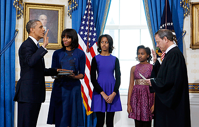 אובמה, לצד משפחתו והשופט רוברטס. הושבע תוך פחות מדקה (צילום: AP)