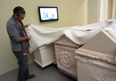 אחד מאוצרי התערוכה מסיר הכיסוי מעל הסרקופגים של הורדוס (צילום: דני הרמן)