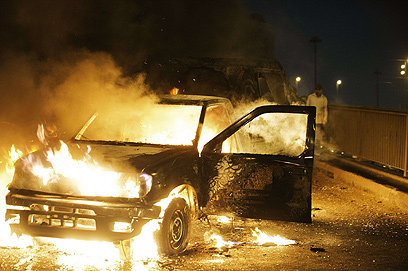 מכונית עולה באש בהתפרעויות בקהיר. גם הכסף הולך ואוזל (צילום: AFP)