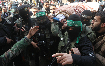 לוחמי חמאס נושאים את גופתה של פרחאת (צילום: AFP)