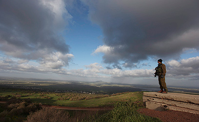 חיילי ישראלי צופה על צדו הסורי של הגבול (צילום: EPA)