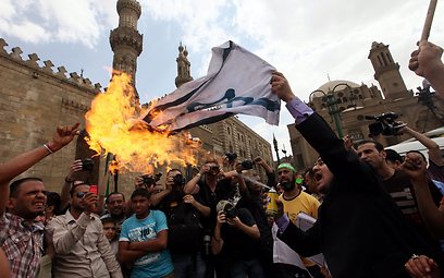מעלים באש את דגל ישראל, היום בקהיר (צילום: EPA)