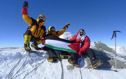 קבוצת המטפסים ודגל פלסטין על פסגת ההר