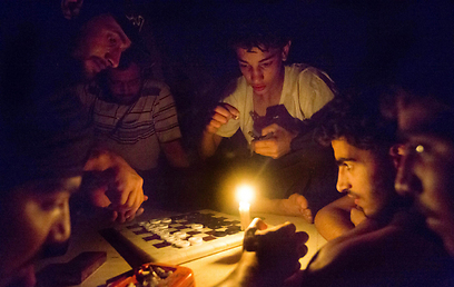 מורדים בדיר א-זור משחקים שש-בש לאור נרות בגלל הגבלות חשמל (צילום: AFP)