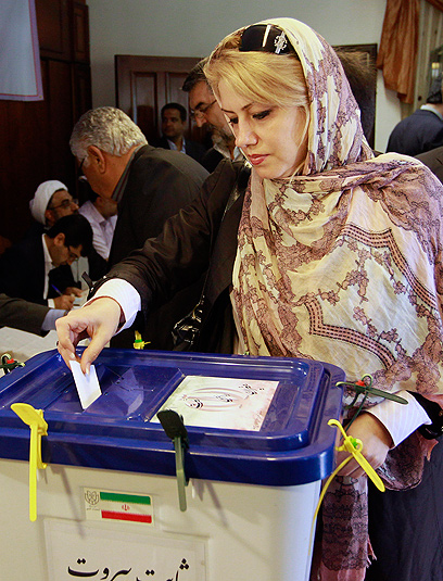 אישה איראנית משלשלת את הפתק שלה לקלפי (צילום: AP)