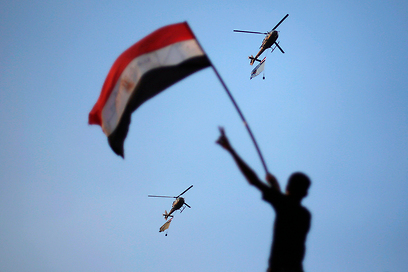 הצבא התייצב לצד העם. מסוקים נושאים את דגלי מצרים מעל שמי קהיר (צילום: רויטרס)