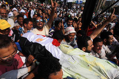 נושאים את גופתו של אחד ההרוגים, היום במצרים (צילום: רויטרס)