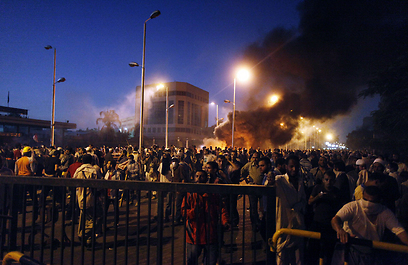 עשן ולהבות באזור המהומות, לפנות בוקר. יותר מ-300 פצועים (צילום: AFP)
