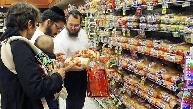 Dovid Lepkivker and Eli Chaikin inspect packages of bagels with Mary Semple and her grandson Levi Weitner in a grocery store in Helena, Mont (Photo: AP)